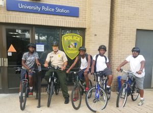 Cpl. Milton Johnson alongside area youth before setting out on an afternoon of biking on and around campus