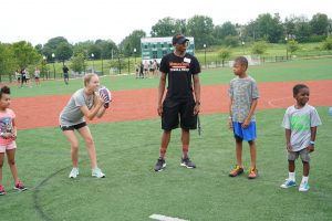 Morgan athlete with kids on a playing field